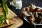 Cooking garden snails. Wooden cutting board and ingredients. Fresh mint leaves, green scallion, knife, pepper, salt cellar and