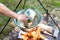 Cooking goulash or stew outdoors in cast-iron cauldron.