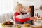 Cooking with granny. Adorable girl with grandmother hugging while preparing festive meal together in kitchen