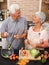 Cooking, health and smile with old couple in kitchen for salad, love and nutrition. Happy, help and retirement with