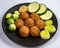 Cooking of healthy vegetarian food, tasty check pea falafels and frehs green vegetables