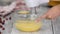 Cooking and home concept. Closeup, woman beat custard with hand mixer. Preparation of sweet cream.