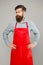 Cooking at home. Helping around house. Bearded man in cook uniform. Mature shop assistant. Chef in red apron. Restaurant