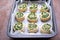 Cooking homemade buns with green onions, nettles, cheese and egg, the third step. Finished shaped buns in the pan for baking.