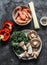 Cooking ingredients for   asian style lunch - shrimp, egg noodles, variety of mushrooms, sweet pepper, kale on a dark background,