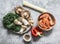 Cooking ingredients for  asian style lunch - shrimp, egg noodles, variety of mushrooms, sweet pepper, kale on a grey background,