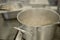 Cooking in the kitchen. An aluminum pot is steaming on an electric stove.