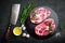 Cooking on kitchen table fresh raw pork marbled steaks on black background