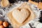 Cooking with love. Dough in heart shape top view. Baking ingredients on the wooden table