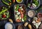 Cooking lunch - fresh raw vegetables, quinoa, rice, spices on a dark background.