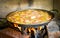 Cooking and making a traditional Spanish Paella over open fire w