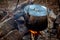 Cooking meal in a kettle on burning campfire in wild camping