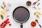 Cooking mockup. Frying pan among spices and vegetables on white desk top-down copy space