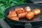 Cooking in nature. Sausages in a frying pan. Side view. Appetizing look