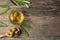 Cooking oil in bowl, olives and leaves on wooden table, flat lay. Space for text