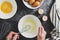 Cooking omlette. Woman& x27;s hands cookingomlette, breaking an fresh egg. Dark background. Food flat lay