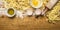 Cooking pasta with eggs, flour, olive oil, rolling pin on wooden rustic background top view close up