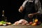 Cooking Peking Duck chef with fruit, on a black background. Horizontal photo, space for menu and design, restaurants, hotel