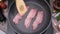 cooking Pieces of flavorful sliced organic bacon fried in a pan
