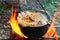 Cooking pilaf in a casserole on the fire close up