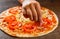 Cooking pizza. hand woman cook puts tomato slice on dough. making Italian pizza