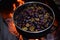 cooking plum jam in a traditional style with firewood. boiling the fruit outside in a large stainless steel pot