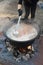 Cooking pot over campfire, stew preparing open grill steaming. Outdoor fireplace camping concept