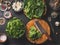 Cooking preparation of delicious vegetarian spinach dish. Cutting board with knife on rustic kitchen background.  Healthy