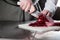 Cooking in a restaurant kitchen. Closeup of hand with knife cutting fresh vegetable. Young chef cutting beet on a white