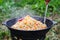 Cooking rice pilaf in a large cast-iron pot on fire