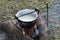 Cooking rice using pot in outdoor nature. Food Camping cooking over a fire using dry firewood and use stone as stove stand.