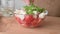 Cooking a salad of cherry tomatoes, feta cheese and arugula microgreen