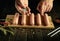 Cooking sausages on the kitchen table. Close-up of a chef hand adding salt to Munich sausages