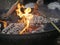 Cooking sausages over a camp fire