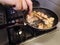 Cooking shrimps in a black pan