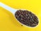 Cooking spices, whole mustard seeds on yellow background