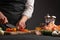 Cooking StirFry vegetables with shrimp. Chef slices cherry tomatoes, on a gray background with shrimp. Seafood