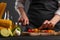 Cooking StirFry vegetables with shrimp. Chef slices cherry tomatoes, on a gray background with shrimp. Seafood