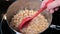 Cooking and stirring garbanzo beans in a pan on a flat cook top