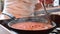 Cooking and stirring tomato sauce for spaghetti on frying pan, close-up