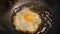 Cooking sunny side up fried egg in oil Chinese wok Asian cuisine style