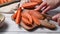 Cooking sweet potato wedges, female hands slicing raw sweet potatoes on cutting board.