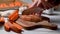 Cooking sweet potato wedges, female hands slicing raw sweet potatoes on cutting board.