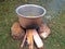 Cooking tasty delicious indian food item during a picnic or outdoor camp using stone made firewood oven and aluminium pot at an op