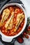 Cooking in tomatoes monkfish fish in a baking dish. Fresh seafood. Gray background. Top view