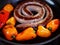 Cooking Traditional South African boerewors with red and yellow peppers