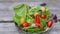 Cooking vegan salad. Woman is pouring oil in vegetable salad in the bowl in slow motion