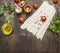 Cooking vegetarian noodles with cherry tomatoes, herbs and spices and oil on a wooden background, noodles lies in vintage pot sp