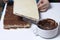 Cooking waffle cake. A woman puts a stack of wafer cakes, smeared with a mixture of cocoa and butter. Alternately with wafer cakes