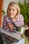 Cooking woman looking at computer while preparing food in kitchen. Beautiful mature woman reading cooking recipe